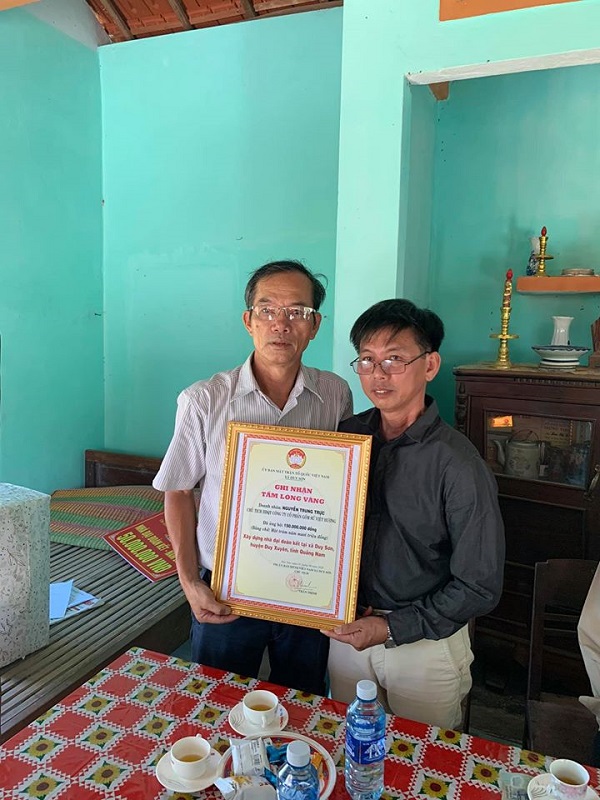 Đại diện UBMTTQVN xã Duy Sơn (bên trái) trao bảng Ghi nhận tấm lòng vàng cho đại diện Công ty CP Gốm sứ Việt Hương.